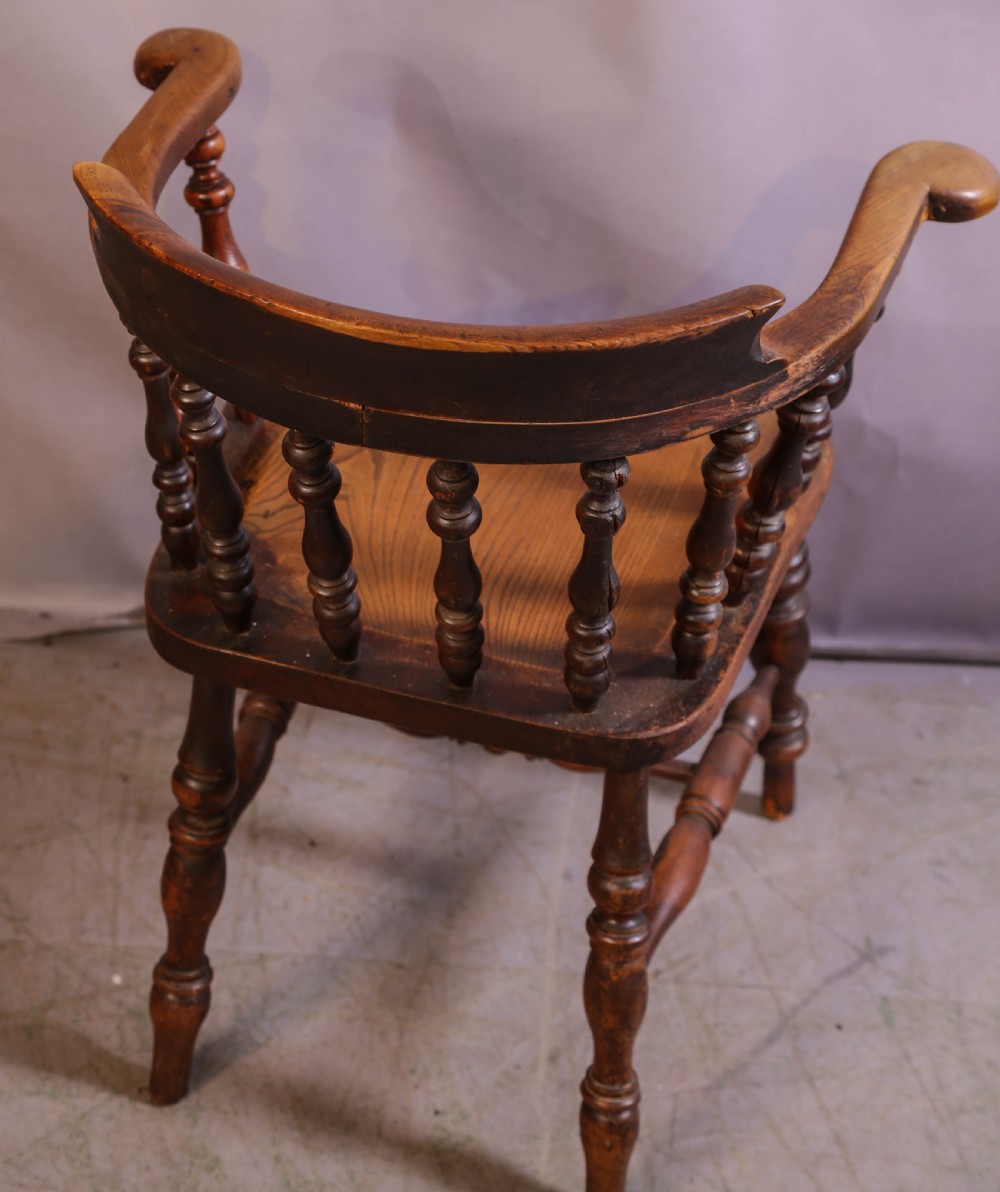 A Victorian captains chair made of polished yew wood featuring a curved crest rail, turned spindles, turned legs, and a solid shaped elm seat. View VII