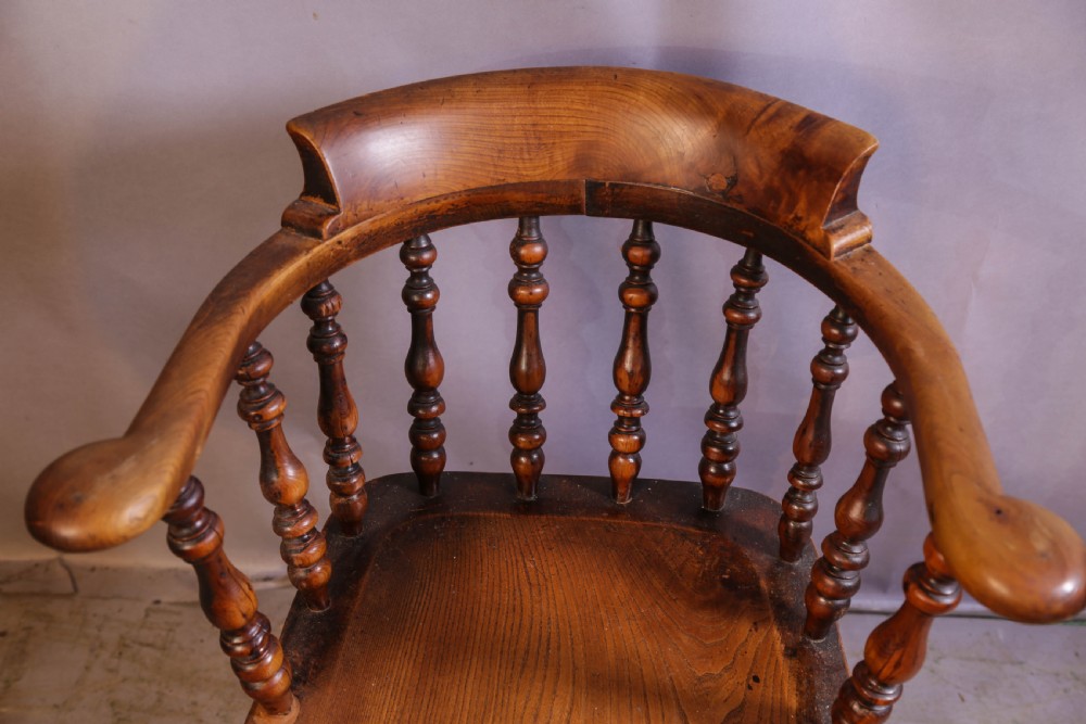 A Victorian captains chair made of polished yew wood featuring a curved crest rail, turned spindles, turned legs, and a solid shaped elm seat. View VIII
