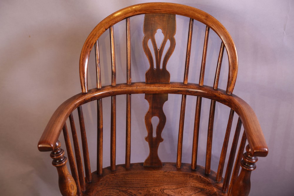 An English ash and elm Windsor armchair featuring a curved hoop back, pierced splat, turned spindles, contoured seat, and turned legs. View IV