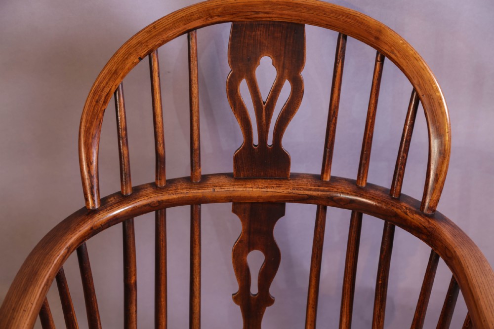 An English ash and elm Windsor armchair featuring a curved hoop back, pierced splat, turned spindles, contoured seat, and turned legs. View VI