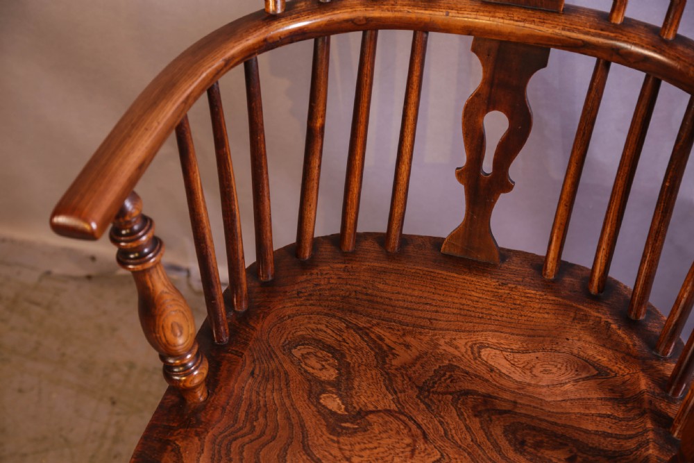 An English ash and elm Windsor armchair featuring a curved hoop back, pierced splat, turned spindles, contoured seat, and turned legs. View VIII