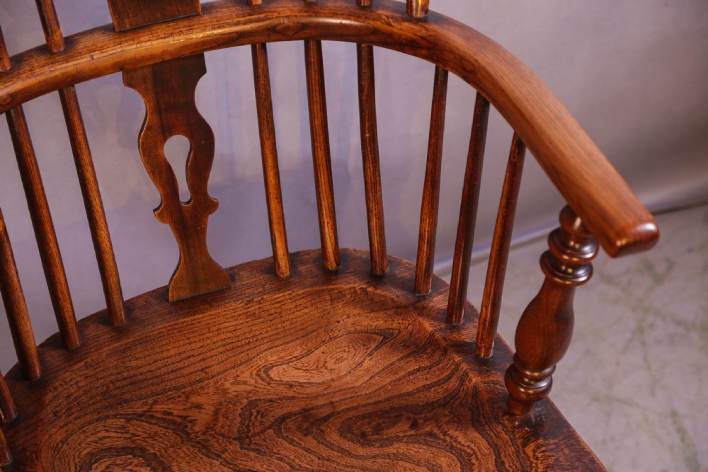 An English ash and elm Windsor armchair featuring a curved hoop back, pierced splat, turned spindles, contoured seat, and turned legs. View IX
