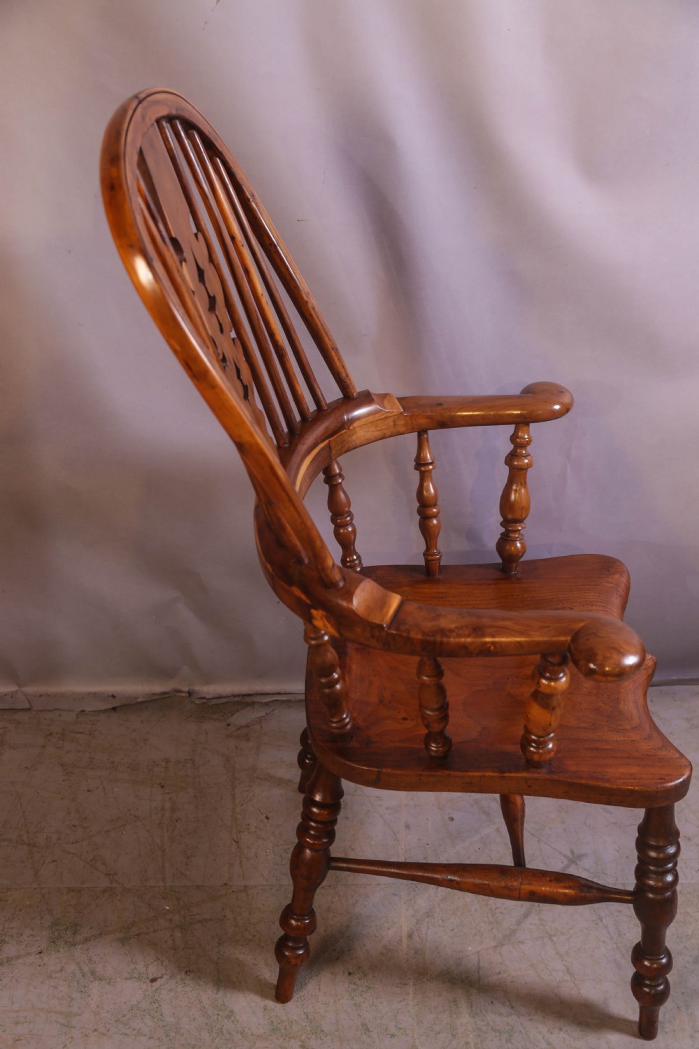 An antique yew wood high-back Windsor armchair featuring a pierced decorative splat, shaped pad arms, turned spindles, and a contoured wooden seat. View II
