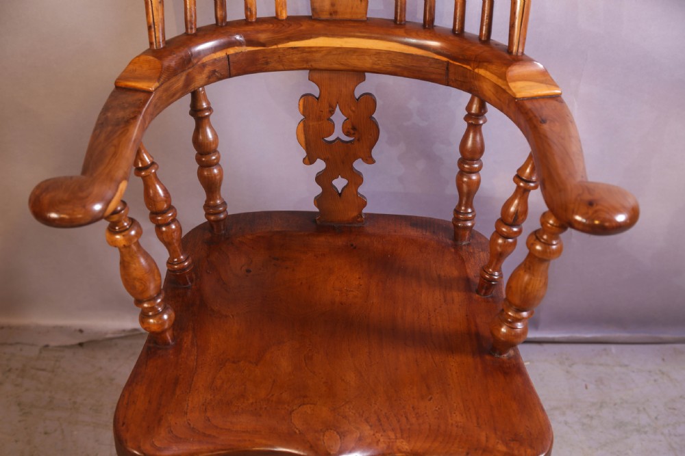 An antique yew wood high-back Windsor armchair featuring a pierced decorative splat, shaped pad arms, turned spindles, and a contoured wooden seat. View IV