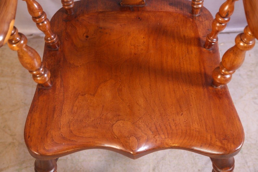 An antique yew wood high-back Windsor armchair featuring a pierced decorative splat, shaped pad arms, turned spindles, and a contoured wooden seat. View VI