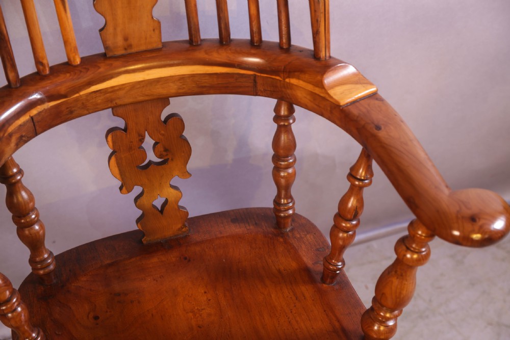 An antique yew wood high-back Windsor armchair featuring a pierced decorative splat, shaped pad arms, turned spindles, and a contoured wooden seat. View VIII