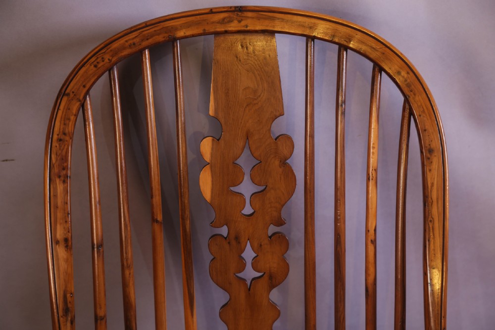 An antique yew wood high-back Windsor armchair featuring a pierced decorative splat, shaped pad arms, turned spindles, and a contoured wooden seat. View IX