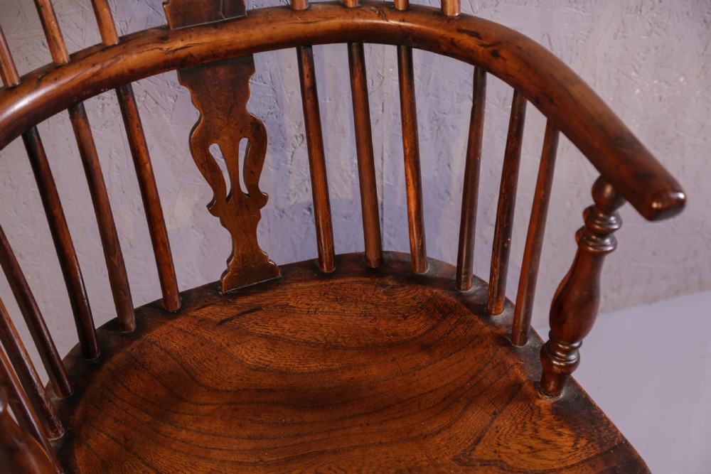 An antique yew wood low back Windsor chair featuring a contoured saddle seat, pierced splat back, turned spindles, and a curved stretcher connecting turned legs. View VIII