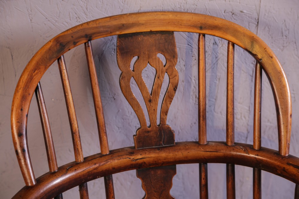 An antique yew wood low back Windsor chair featuring a contoured saddle seat, pierced splat back, turned spindles, and a curved stretcher connecting turned legs. View IX