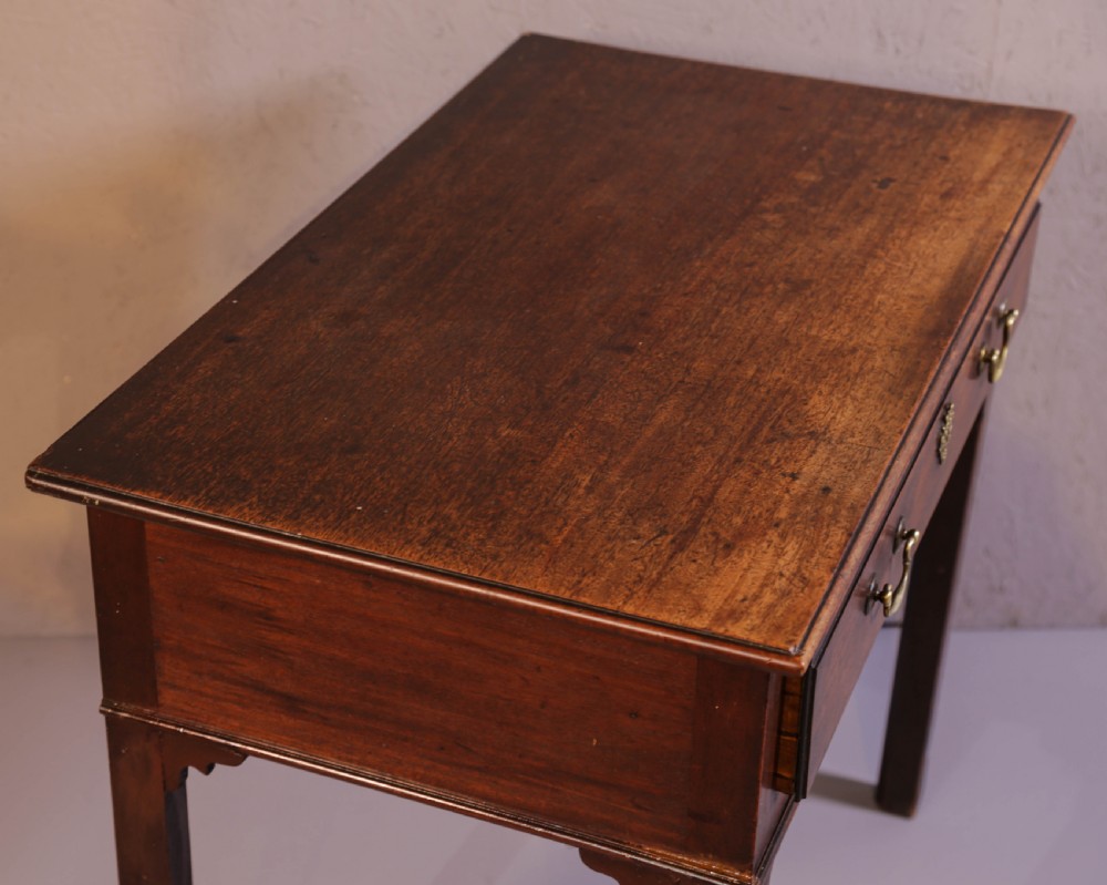 A dark Georgian mahogany side table featuring a single drawer with brass swan neck handles and square legs. View IV
