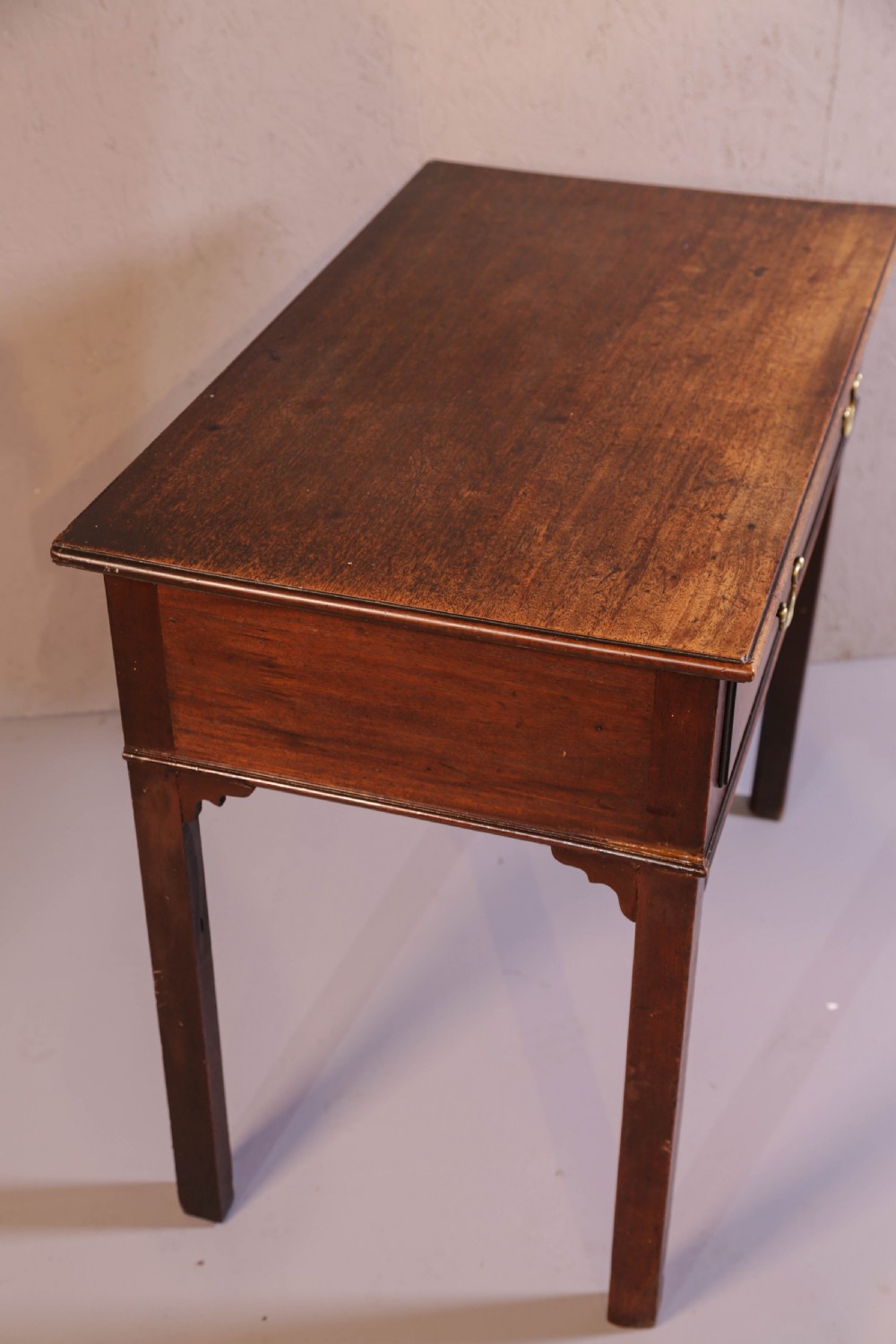A dark Georgian mahogany side table featuring a single drawer with brass swan neck handles and square legs. View VIII