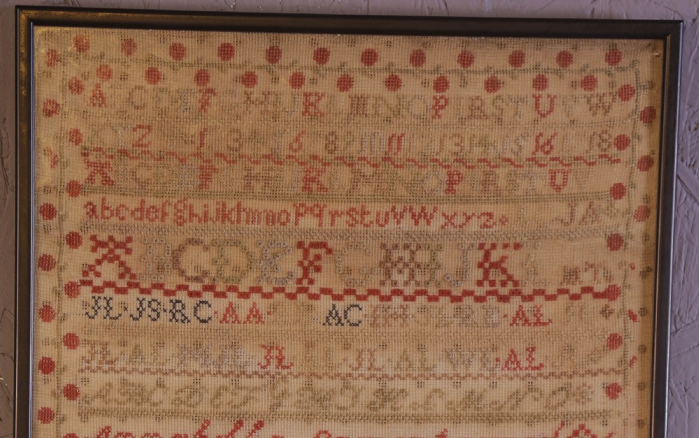 Framed 1851 Victorian needlework sampler featuring alphabets, numbers, and an embroidered depiction of the Crystal Palace on a linen ground. View II