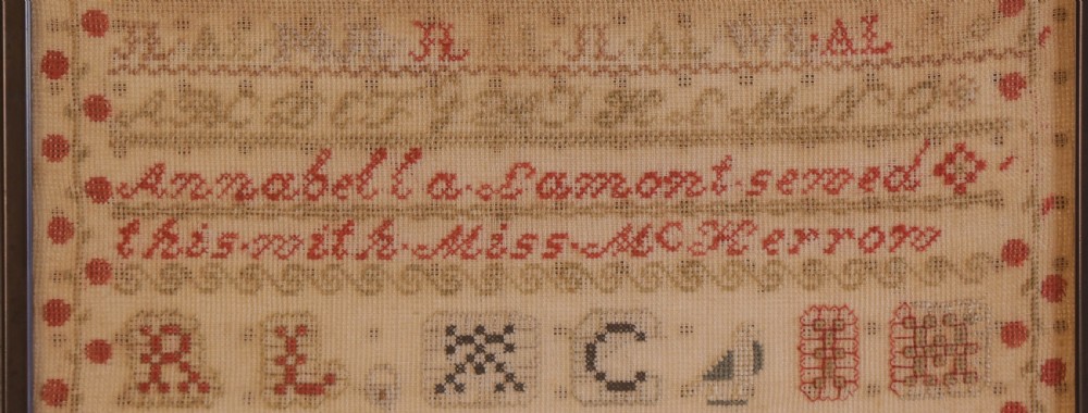 Framed 1851 Victorian needlework sampler featuring alphabets, numbers, and an embroidered depiction of the Crystal Palace on a linen ground. View V