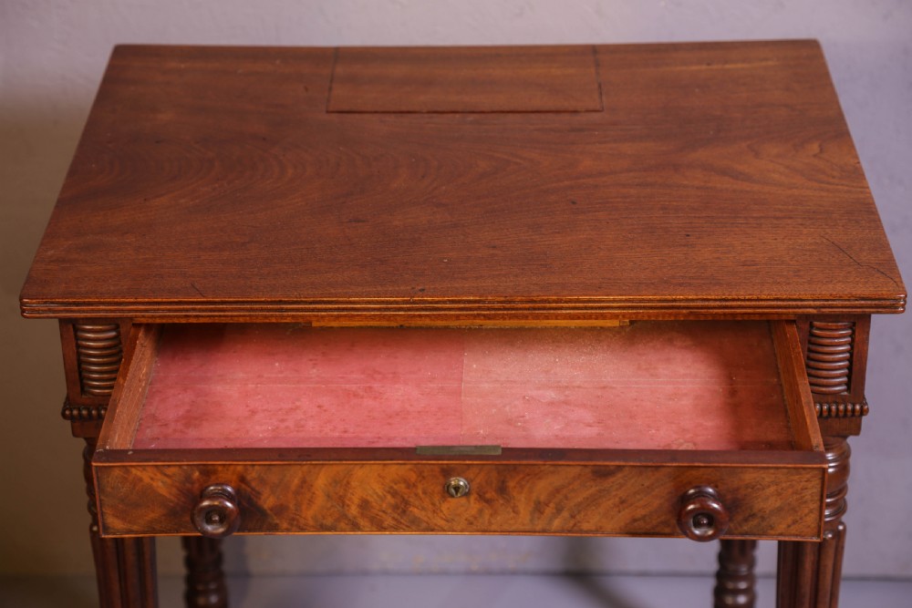 An antique mahogany library table featuring turned reeded legs with brass castors, a single frieze drawer with turned wooden handles, and a rectangular top. View II