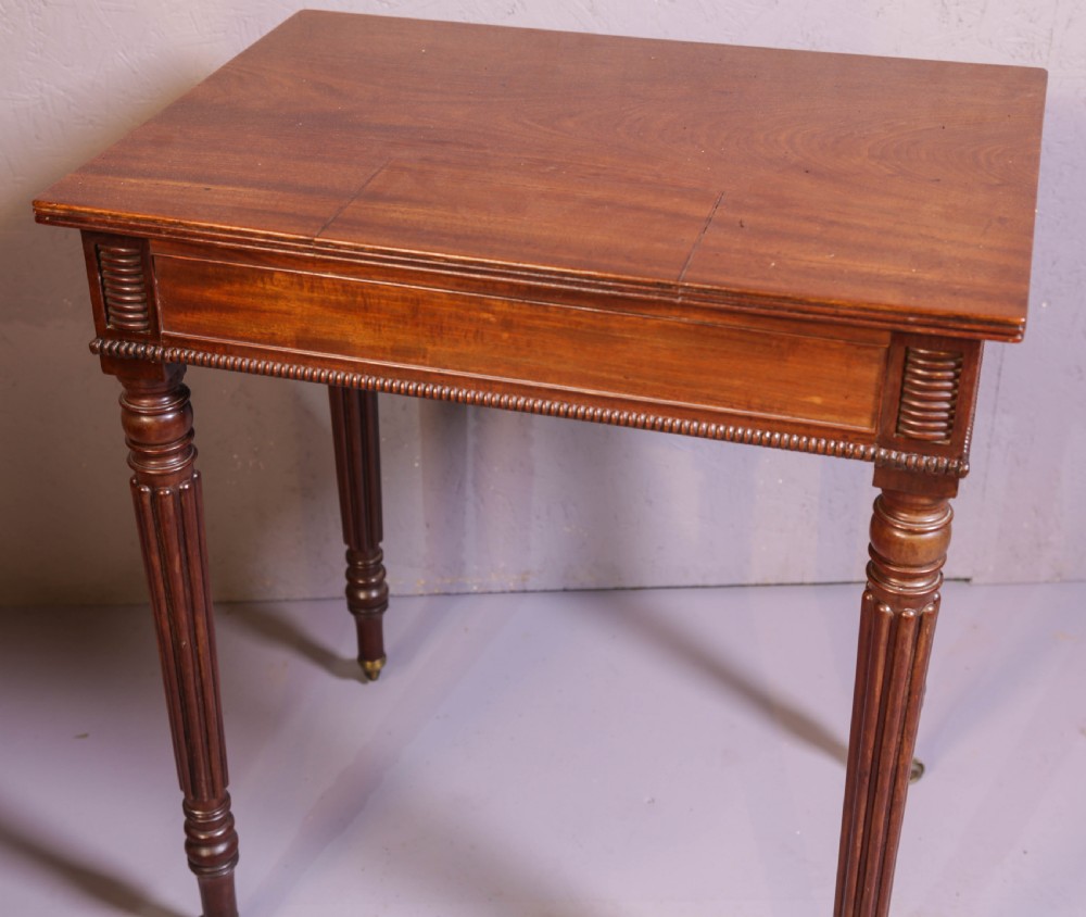 An antique mahogany library table featuring turned reeded legs with brass castors, a single frieze drawer with turned wooden handles, and a rectangular top. View VII