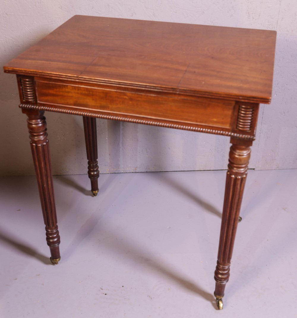 An antique mahogany library table featuring turned reeded legs with brass castors, a single frieze drawer with turned wooden handles, and a rectangular top. View VIII