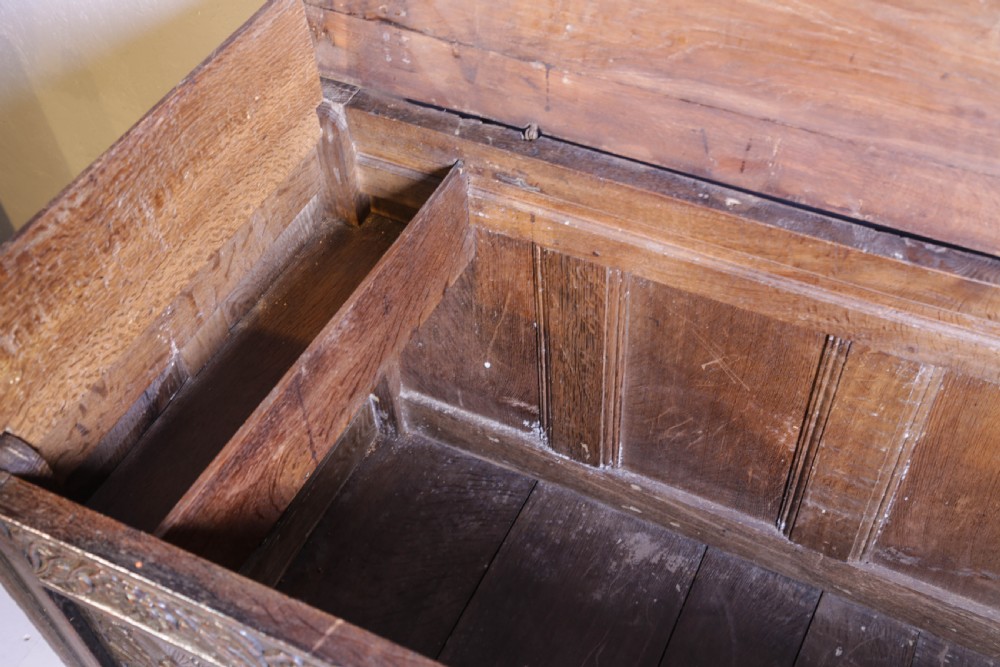 A dark brown oak coffer featuring four carved floral front panels beneath a carved lunette frieze. View XIV