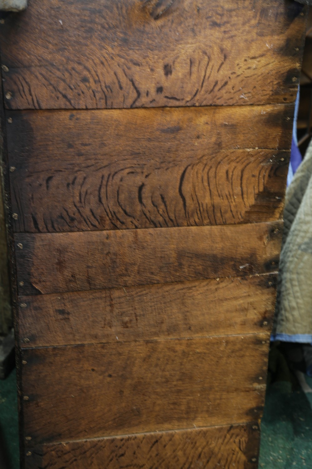 A dark brown oak coffer featuring four carved floral front panels beneath a carved lunette frieze. View XIX