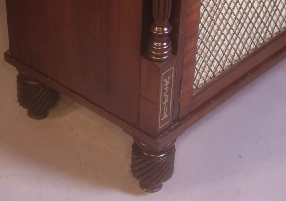 A Regency rosewood chiffonier with brass inlay, a long drawer featuring lion mask handles, and lower double doors with brass wire grilles over fabric. View VI