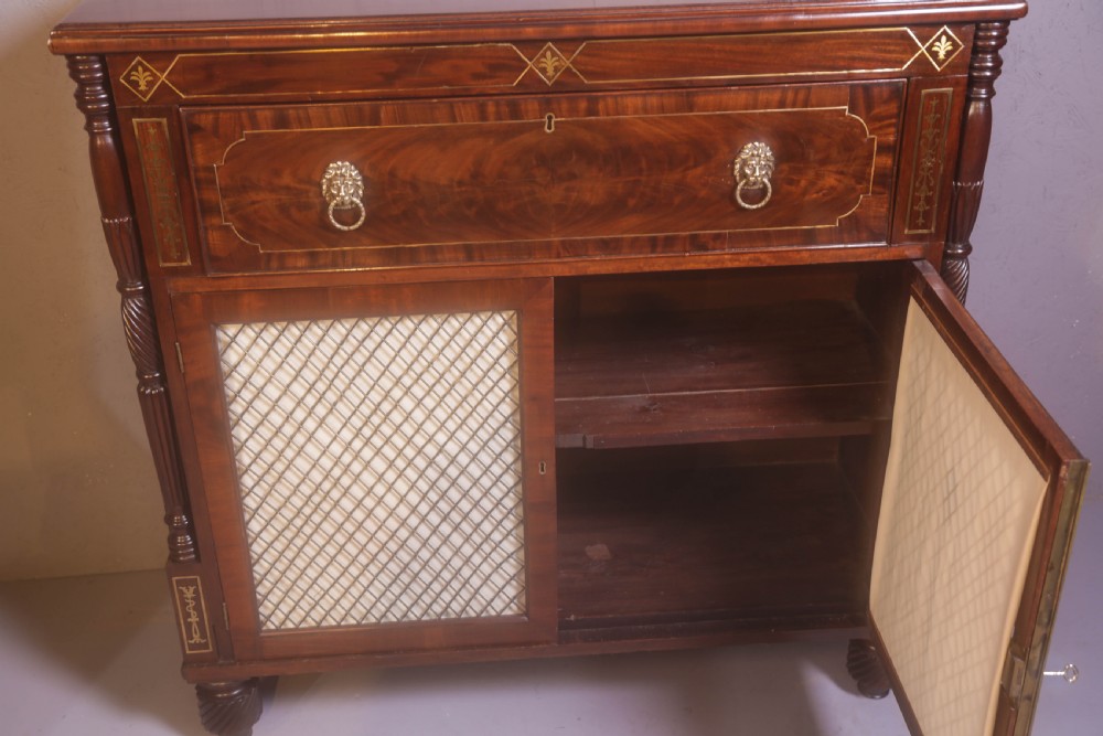 A Regency rosewood chiffonier with brass inlay, a long drawer featuring lion mask handles, and lower double doors with brass wire grilles over fabric. View XI