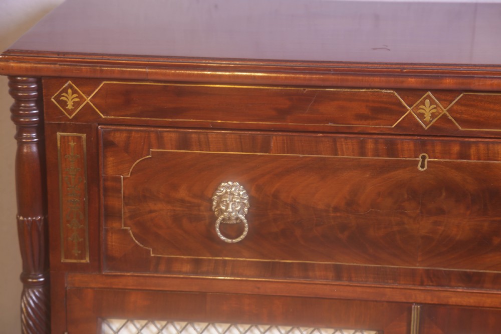 A Regency rosewood chiffonier with brass inlay, a long drawer featuring lion mask handles, and lower double doors with brass wire grilles over fabric. View XIV