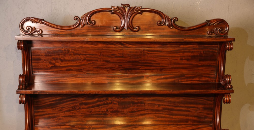 A three-tier Victorian mahogany wall shelf featuring an ornate carved cresting rail and curved side supports. View II