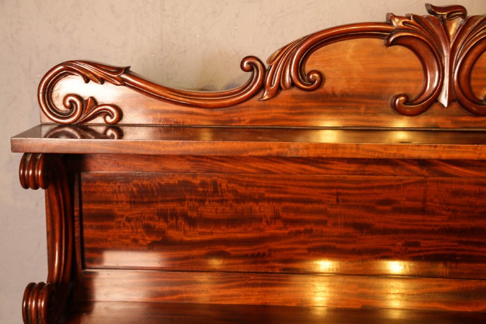 A three-tier Victorian mahogany wall shelf featuring an ornate carved cresting rail and curved side supports. View VIII