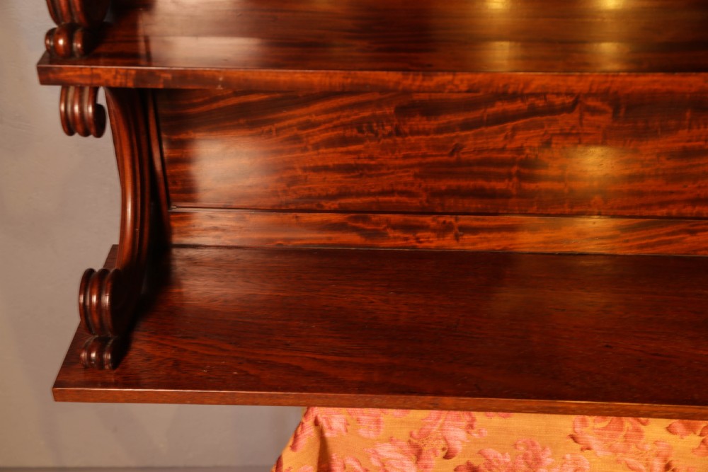 A three-tier Victorian mahogany wall shelf featuring an ornate carved cresting rail and curved side supports. View IX