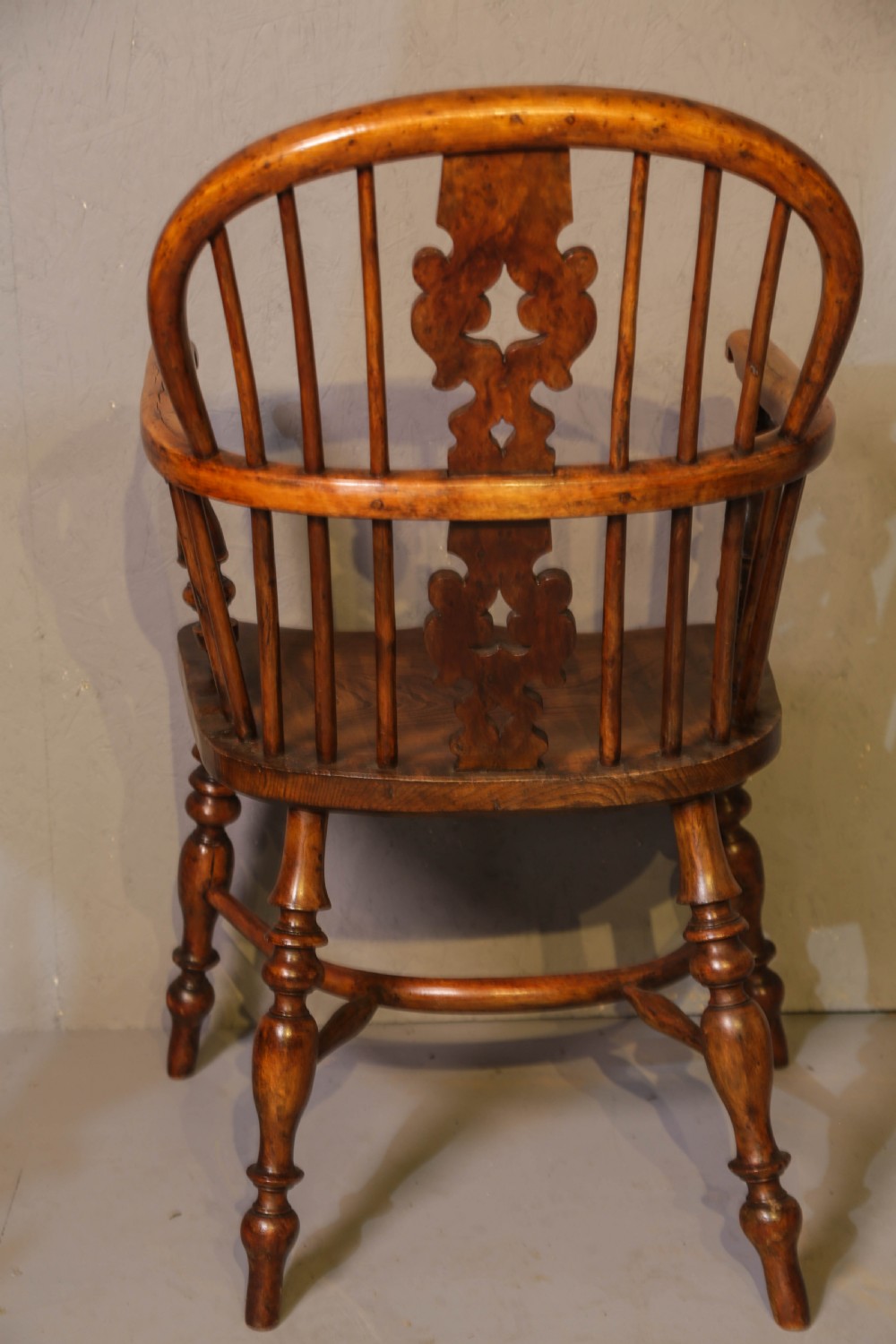 A low-back yew wood Windsor armchair featuring turned legs, a shaped saddle seat, a pierced burr splat, and a curved stretcher. View III