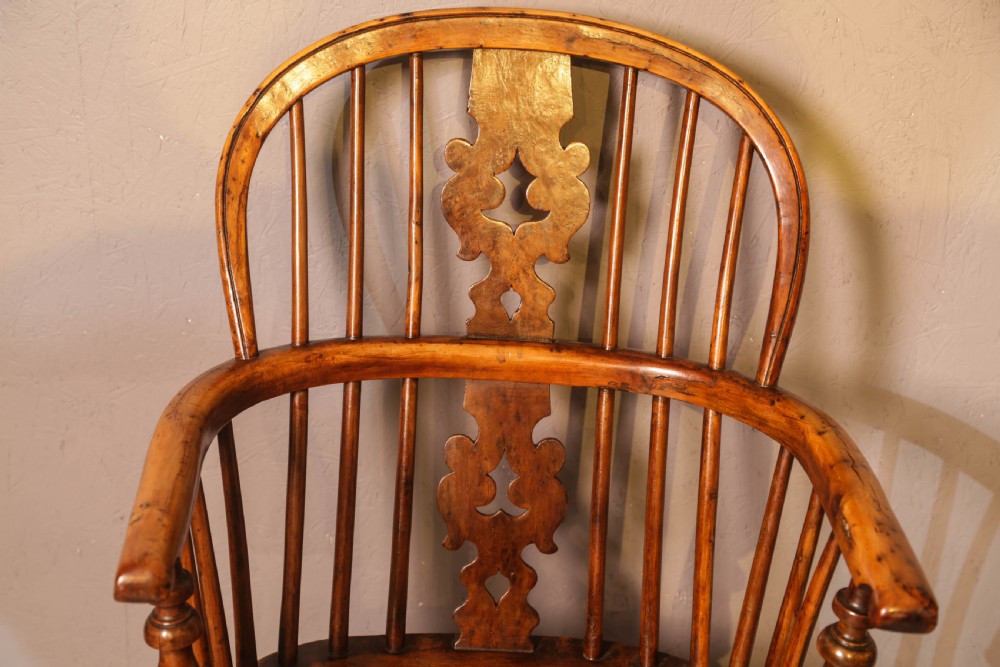 A low-back yew wood Windsor armchair featuring turned legs, a shaped saddle seat, a pierced burr splat, and a curved stretcher. View V