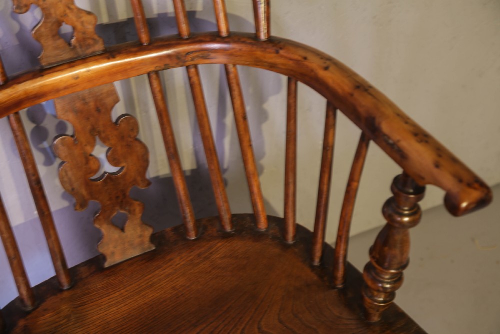 A low-back yew wood Windsor armchair featuring turned legs, a shaped saddle seat, a pierced burr splat, and a curved stretcher. View X