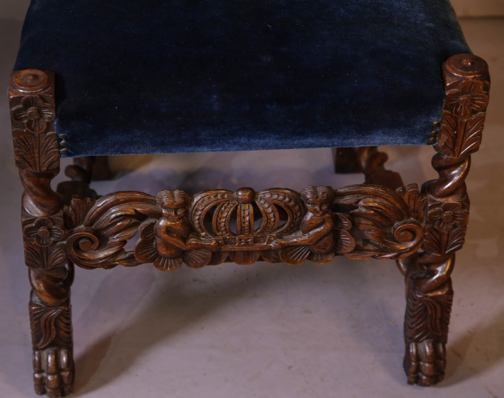 Set of six high-backed Carolean style walnut dining chairs featuring intricate scroll and crown carvings, barley twist pillars, cane back panels, and blue velvet upholstered seats. View IX