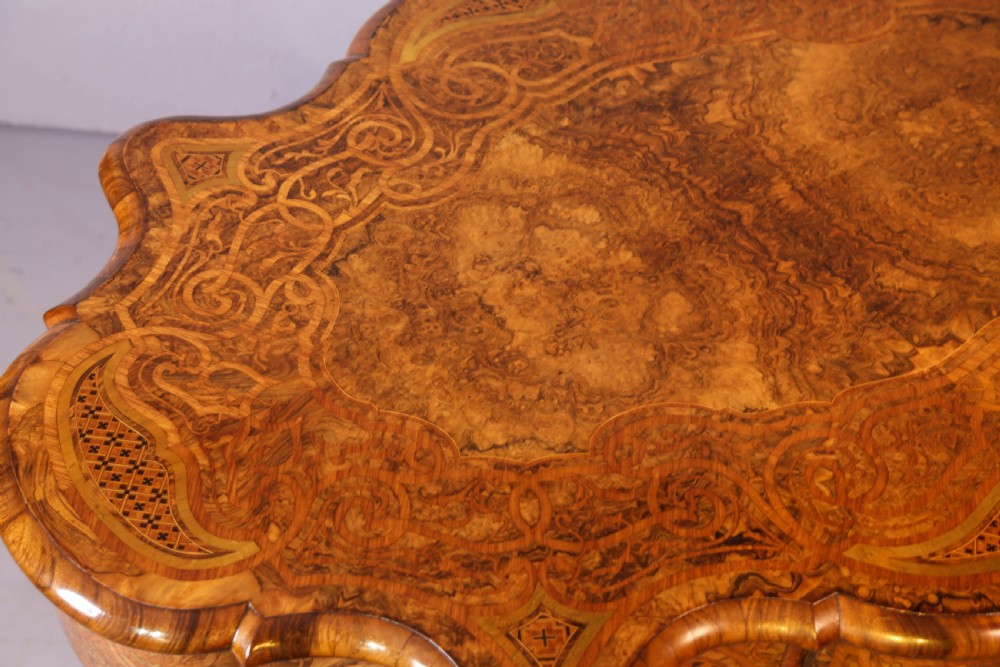 A French Rococo Revival centre table featuring burr walnut marquetry, a serpentine top, cabriole legs, and ornate gilt-bronze mounts. View XII