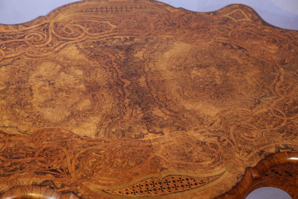 A French Rococo Revival centre table featuring burr walnut marquetry, a serpentine top, cabriole legs, and ornate gilt-bronze mounts. View XV