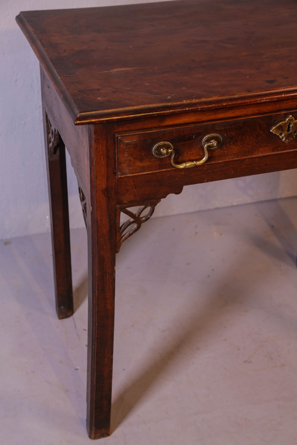 An 18th-century Georgian yew wood side table featuring a single drawer with brass handles, fretwork corner brackets, and straight square legs. View II