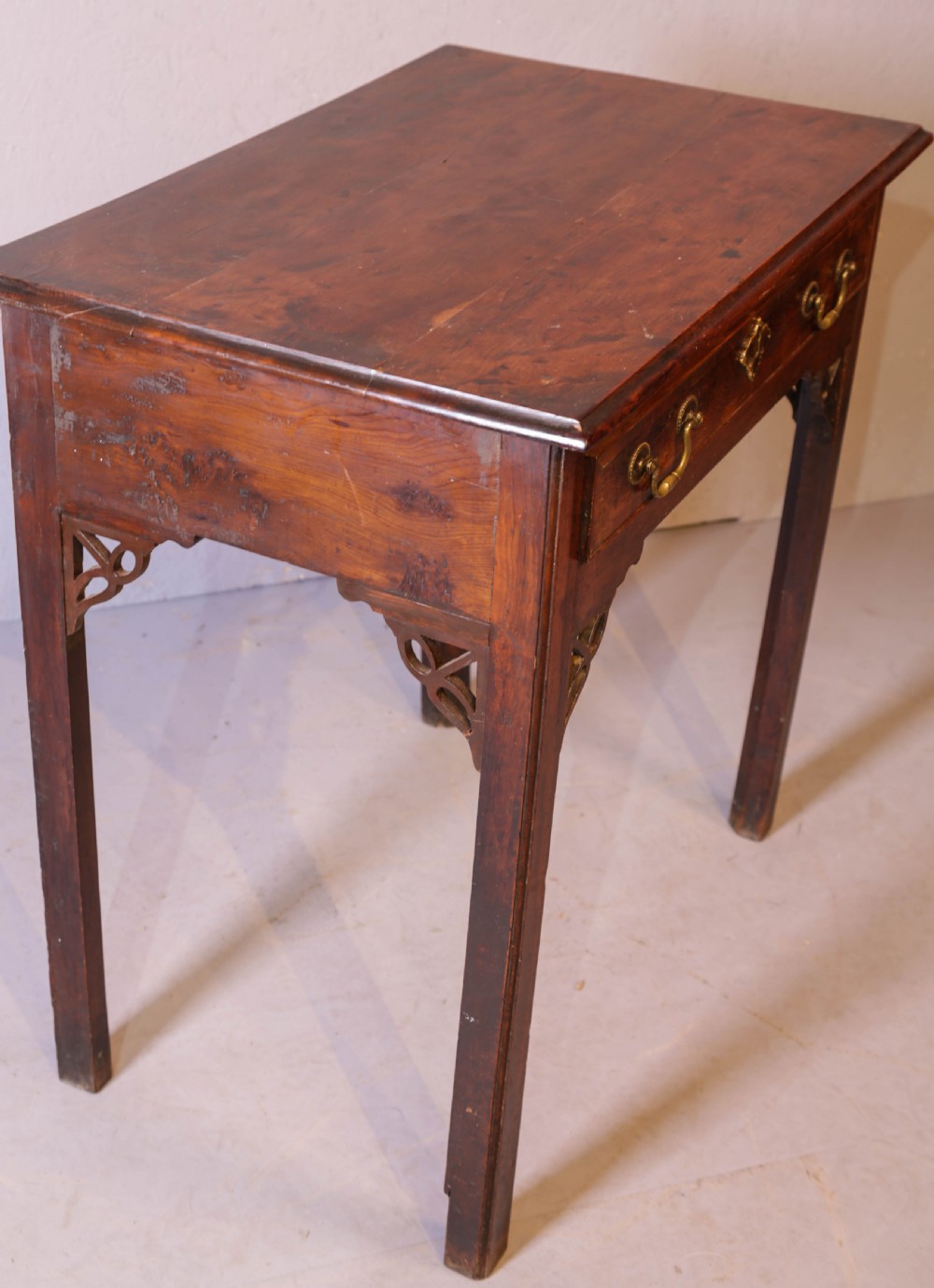 An 18th-century Georgian yew wood side table featuring a single drawer with brass handles, fretwork corner brackets, and straight square legs. View VI