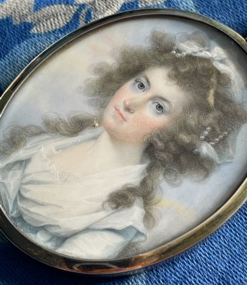 fig 1. An oval Georgian portrait miniature of a lady with powdered curls set within a gold pendant frame.