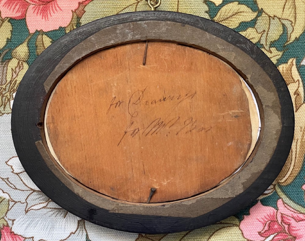 An oval framed Regency cut paper picture featuring a central basket of flowers enclosed by a leafy wreath set inside an ebonised frame with a gilt inner slip. View III