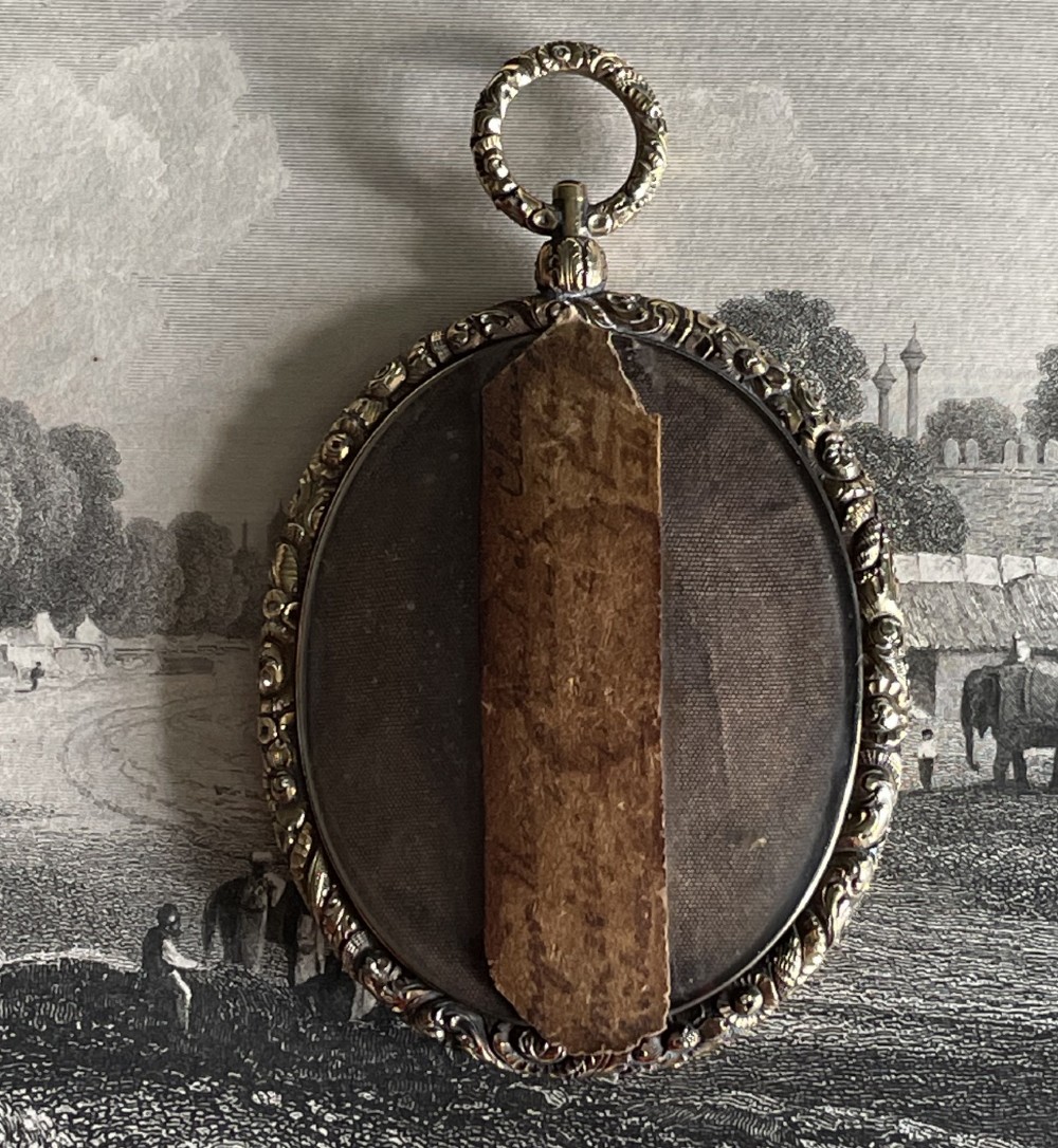An oval Regency portrait miniature depicting a man in military dress uniform framed in an ornate chased gold-tone pendant casing. View II