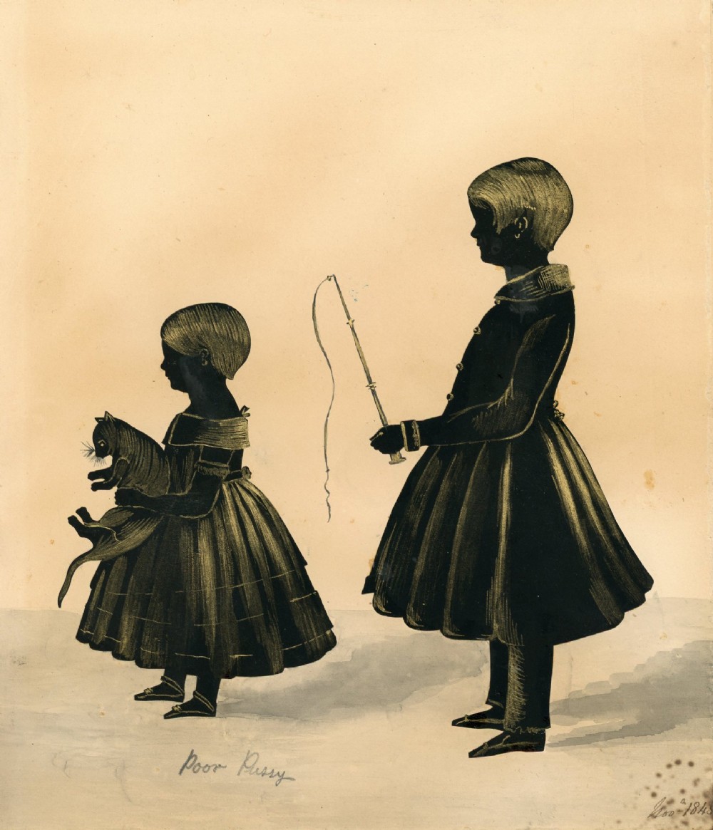 A framed 1846 Victorian cut-paper silhouette depicting two children and a cat, rendered in black ink with gold bronzing details inside a bevelled birdseye maple wood frame. View II
