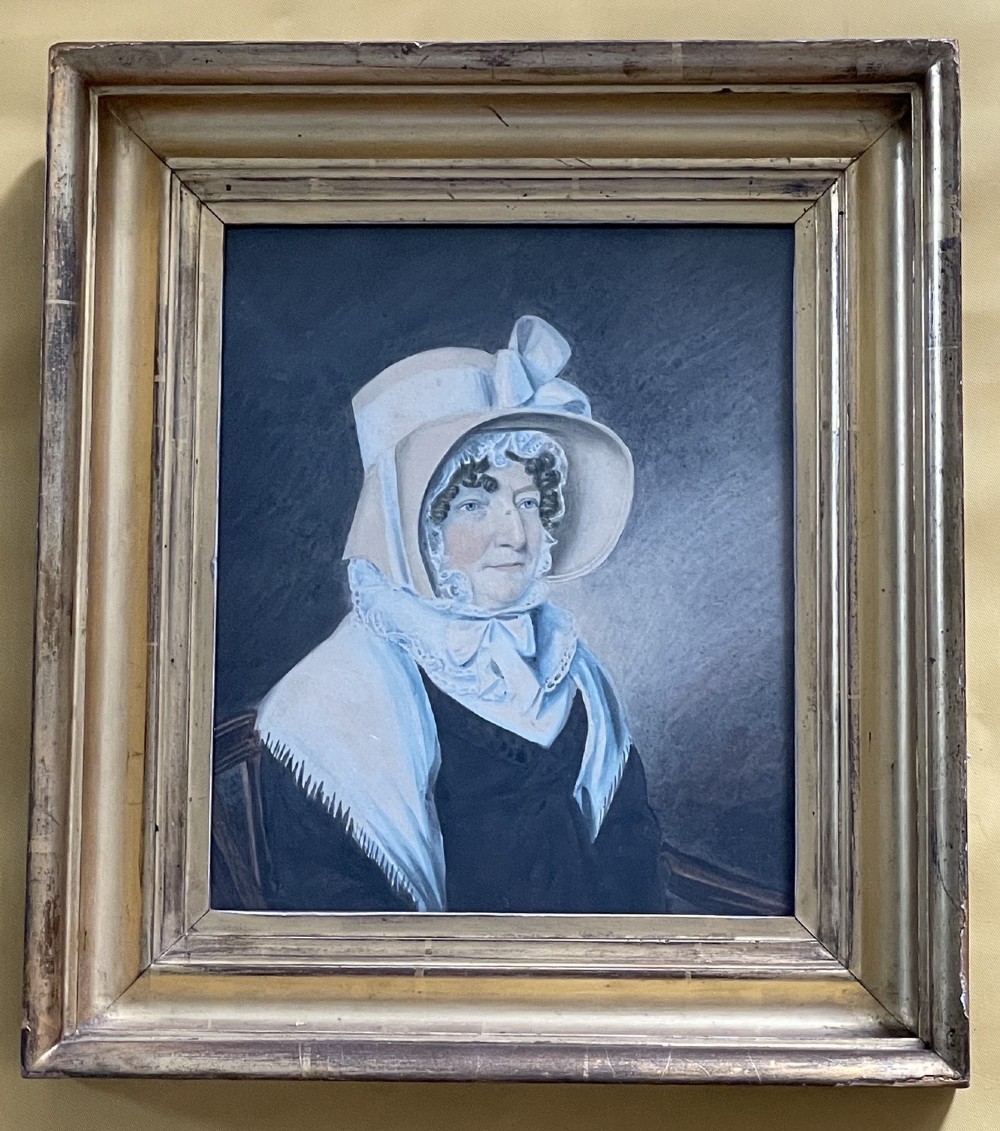 A pair of early 19th-century framed watercolour portraits depicting a man in a dark coat and a woman in a bonnet, housed in moulded giltwood frames. View III