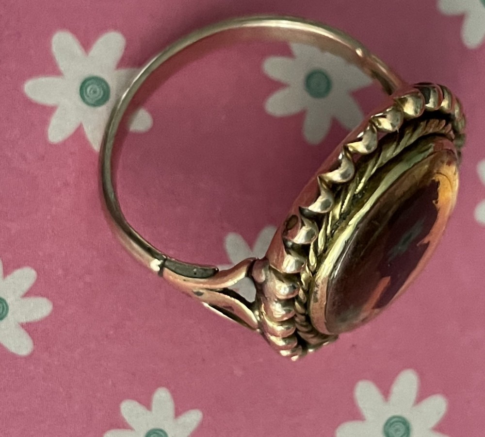 An antique Georgian oval ring featuring a reverse-painted verre eglomise silhouette portrait set within a beaded gold bezel. View V