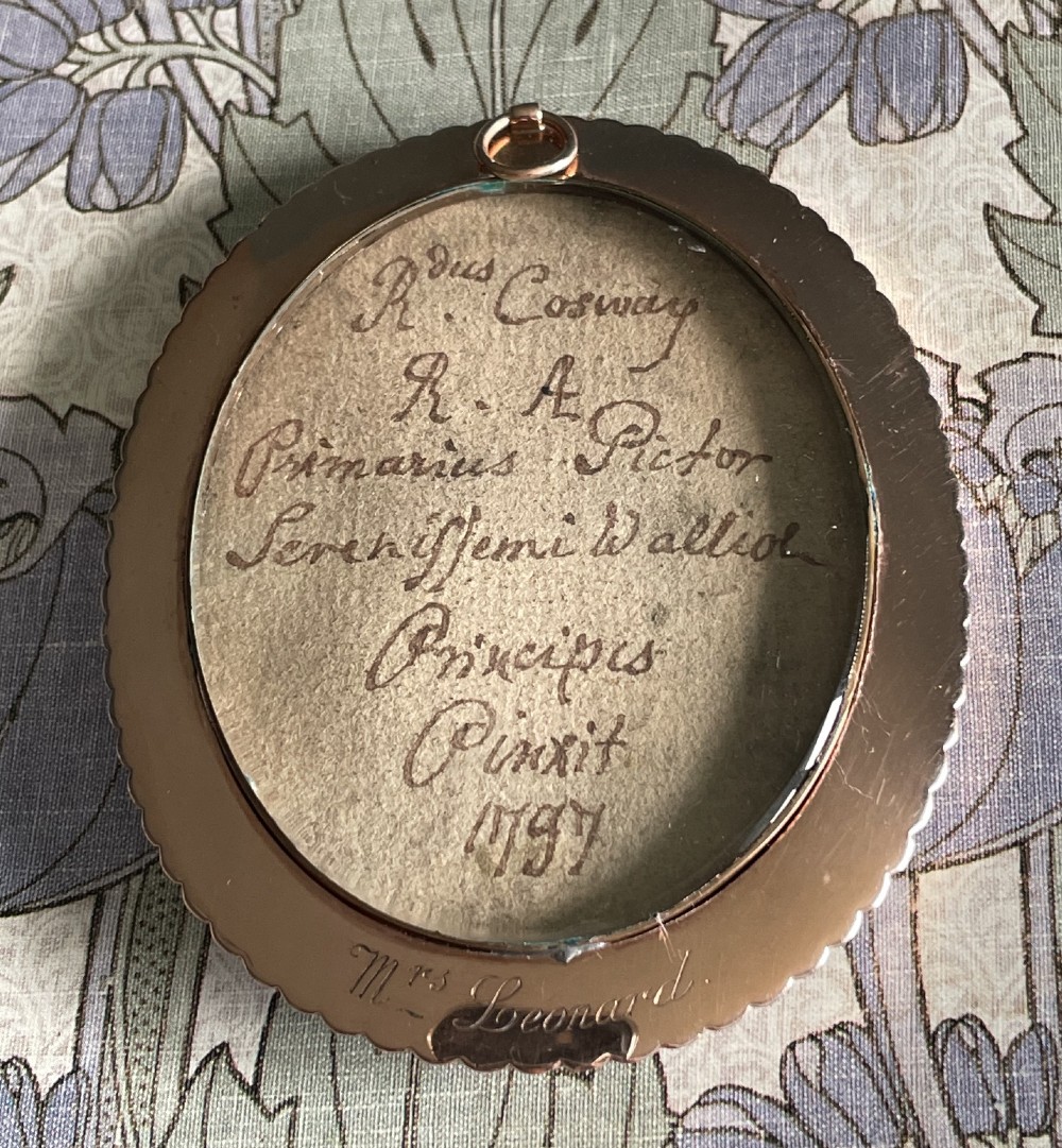 An oval Georgian portrait miniature depicting a woman with curled hair in a blue dress, enclosed within a pearl-set frame. View IV