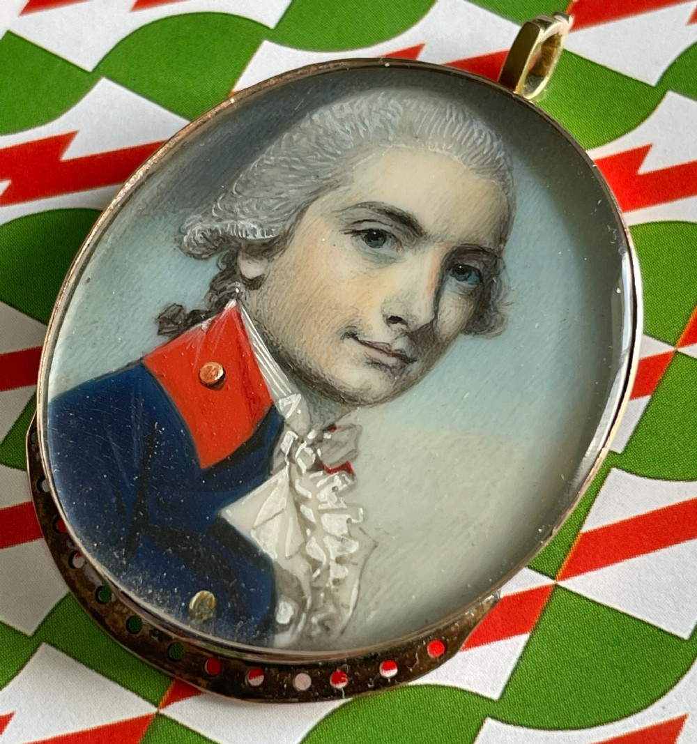 An oval Georgian portrait miniature depicting a young officer in a blue uniform coat with red collar facings, mounted in a gold pendant casing. View III