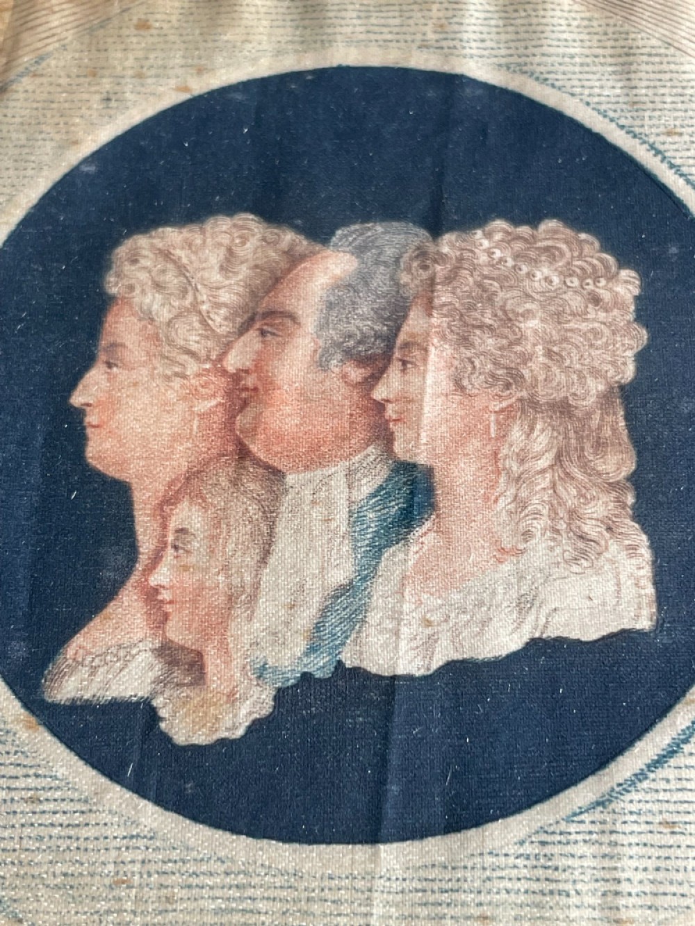 An antique silk print depicting profile portraits of Louis XVI and his family inside a circular medallion, enclosed within a deep square mahogany frame. View III