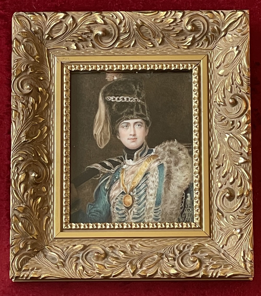 A framed portrait miniature depicting Lieutenant General Charles Vane-Stewart in a Hussar military uniform with a busby hat, set inside a heavily carved gold gilt frame.