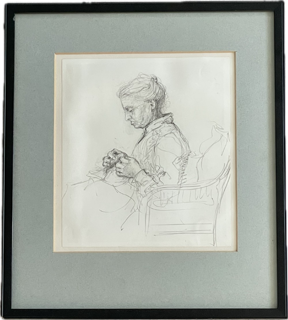 A framed pencil sketch of an elderly woman seated in a chair doing needlework, rendered in graphite on light paper with a grey mount and black frame.