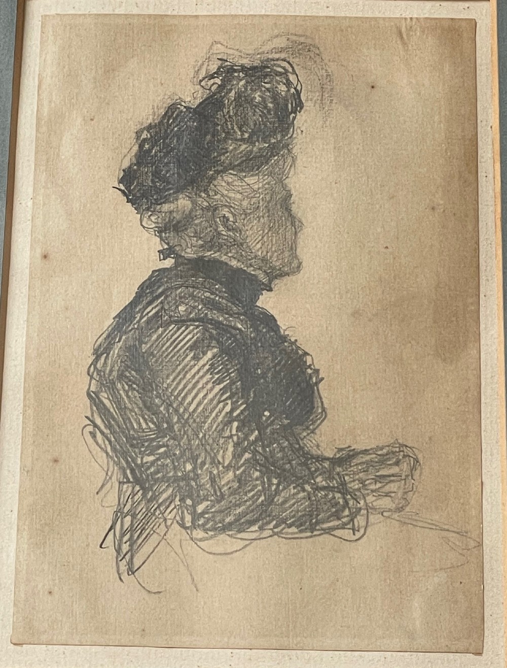 A framed antique profile drawing of a woman in an Edwardian hat, rendered in graphite on paper with a slate grey mount and slim gold gilt frame. View II