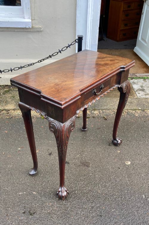 A GEORGE II CARVED MAHOGANY CARD TABLE