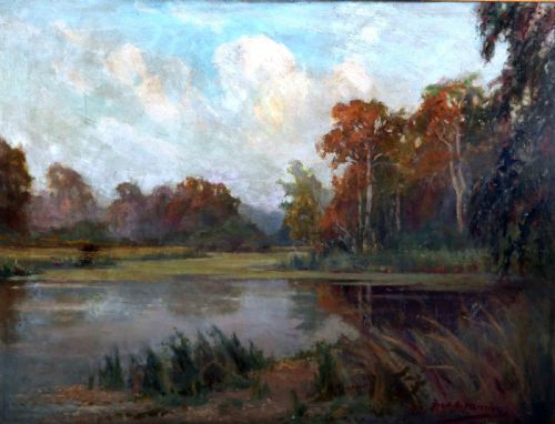 fig 1. A framed oil painting depicting an autumnal lake landscape with orange trees and reflections on dark water, set within an ornate gilded frame.